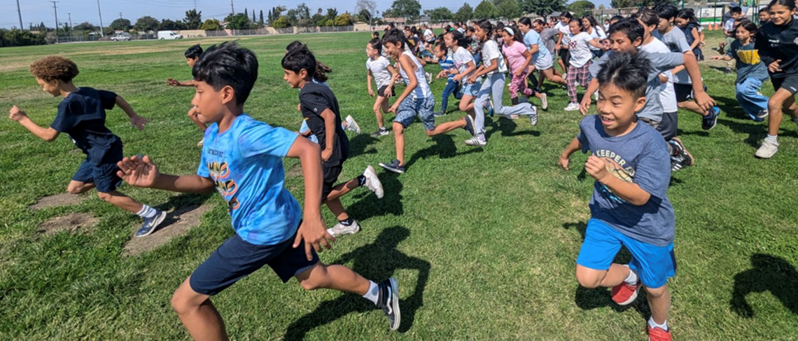 Upper grade students running in a field for the Big Run