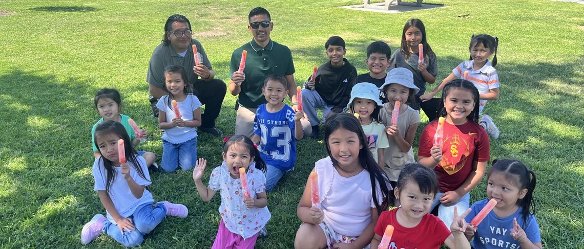 Students enjoying popsicles with the principal